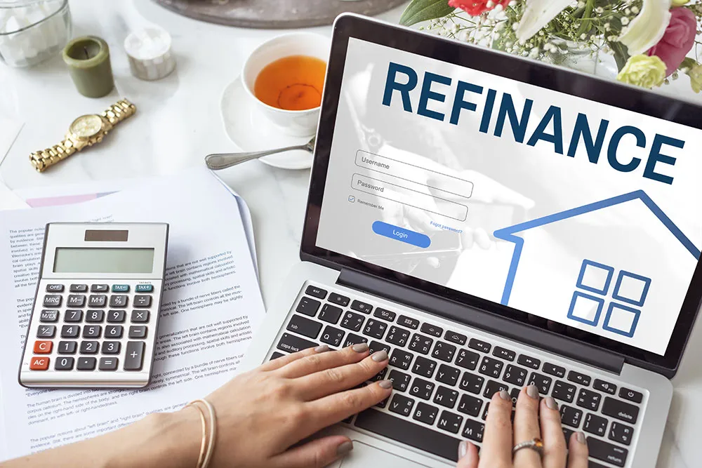 New Zealand homeowner reviewing mortgage refinancing documents with a calculator and house keys