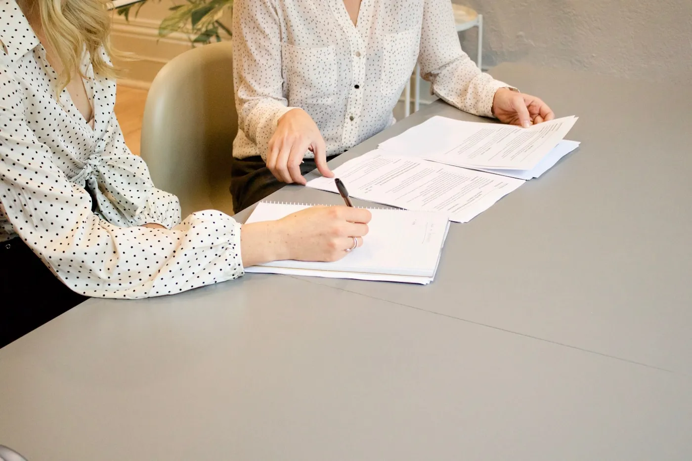 Two people reviewing and signing a property buyout agreement