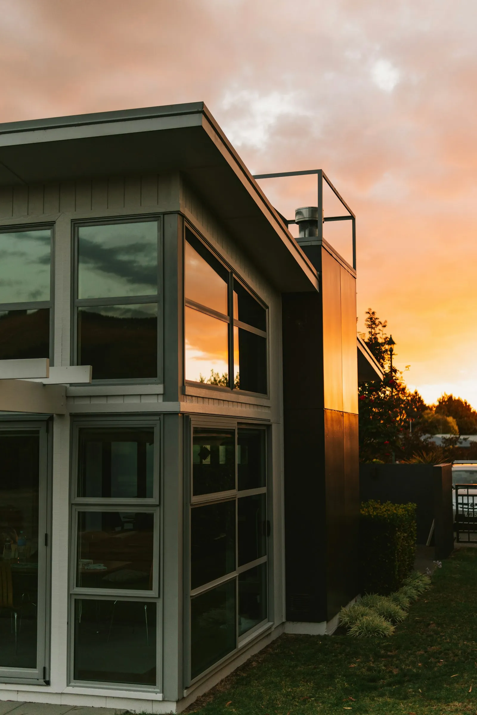 A modern New Zealand home lit by a golden-hour sunset
