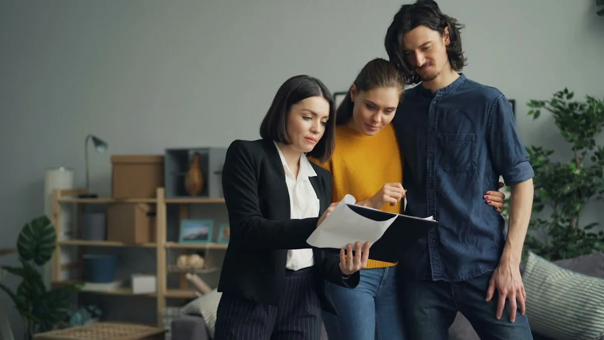 A young couple reviewing paperwork with an adviser, moving boxes in the background