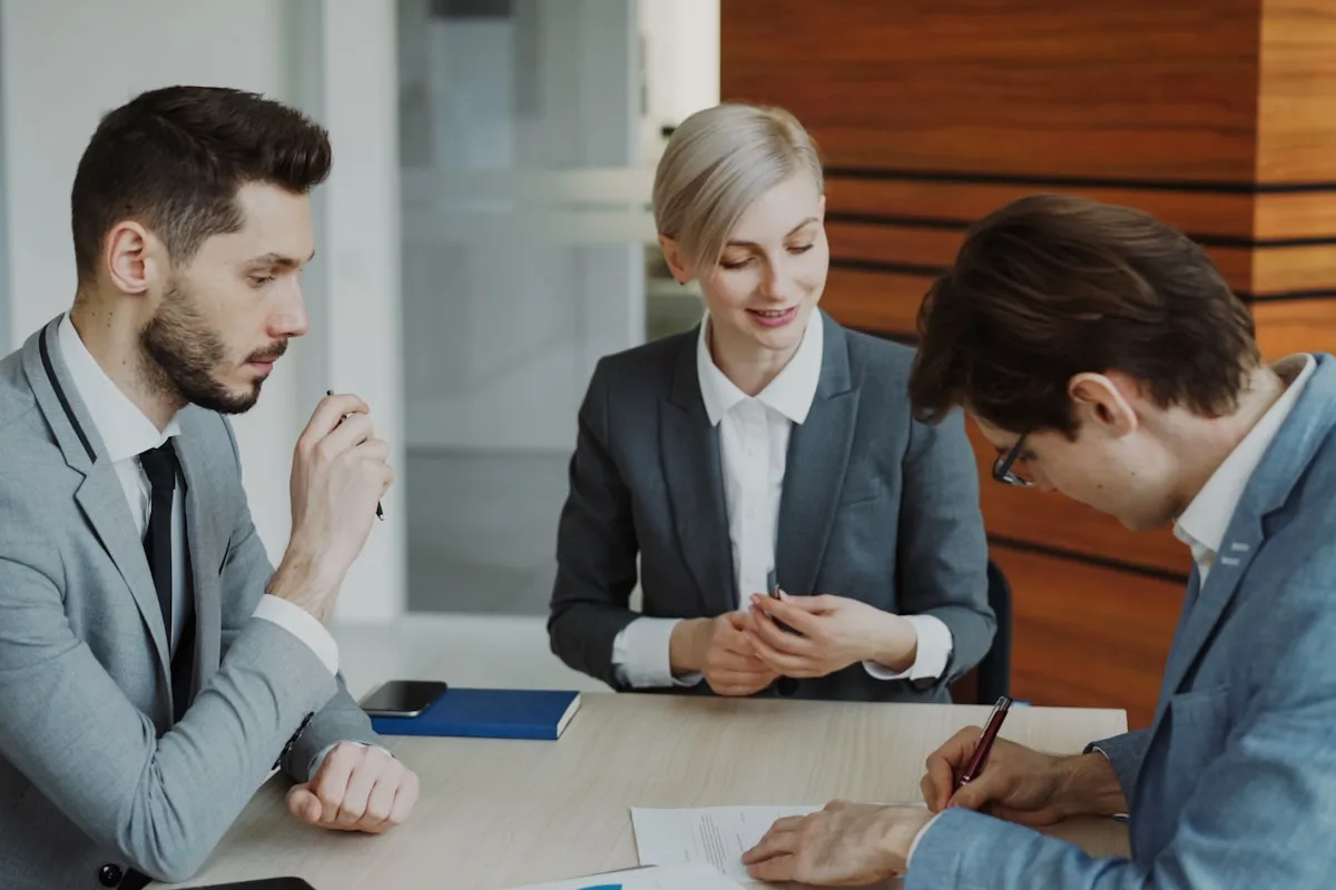 A lawyer explaining discharge documents to clients across a desk in a modern office
