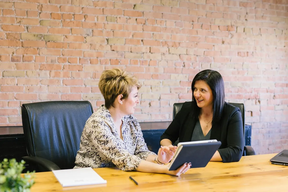 Two colleagues reviewing a financial plan on a tablet