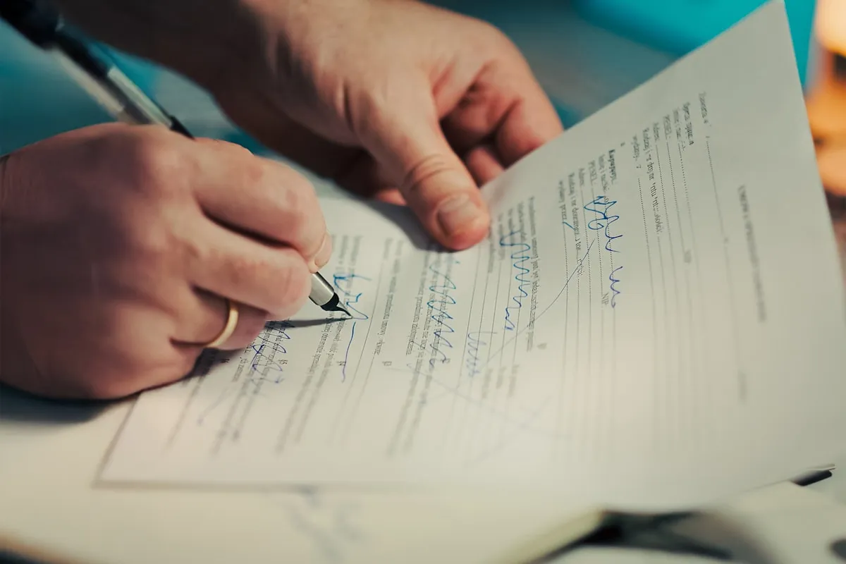 Close-up of hands signing a legal document — the discharge of mortgage instrument